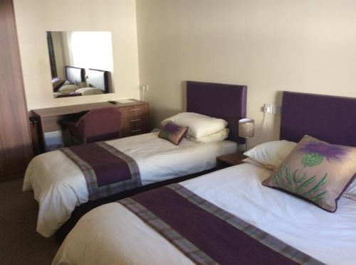 מיטה או מיטות בחדר ב-Glencarse Hotel