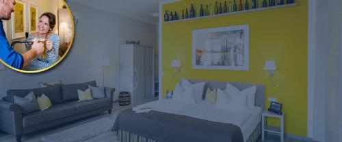 a bedroom with a bed and a couch and a mirror at Pirnscher Hof - Hotel Garni in Pirna