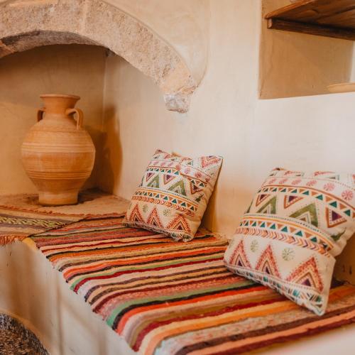 a table with two pillows and a vase on it at Kythera secrets suites in Viarádhika