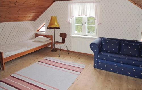 a bedroom with a bed and a couch and a window at Nice Home In Strömsnäsbruk With Kitchen in Sånnamad