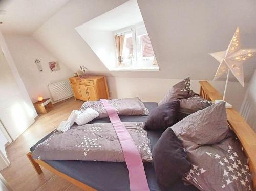 ein großes Bett mit einem rosa Band in einem Zimmer in der Unterkunft Lianes Hus in Garding