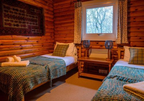 a bedroom with two beds in a log cabin at Pabay in Duirinish