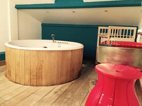 uma banheira de madeira num quarto com um banco vermelho em Magnifique triplex face à la Mer em San-Martino-di-Lota