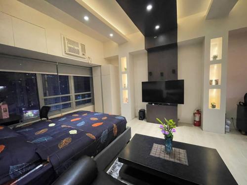 - une chambre avec un lit, un canapé et une télévision dans l'établissement EJ's Staycation 22nd F with 200mbps Wi-Fi and NETFLIX, à Manille