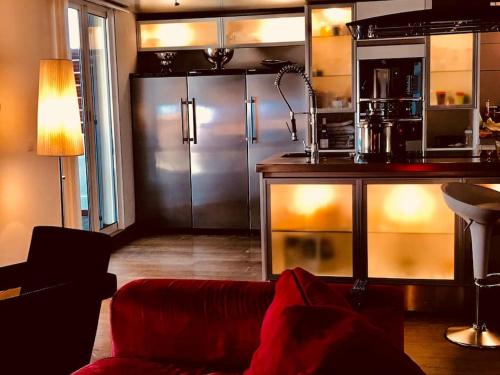 un salon avec un canapé rouge et une cuisine dans l'établissement Magnifique triplex face à la Mer, à San-Martino-di-Lota