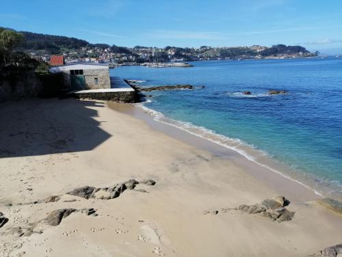a beach with rocks in the sand and the water w obiekcie Ático de Ana w mieście Bueu