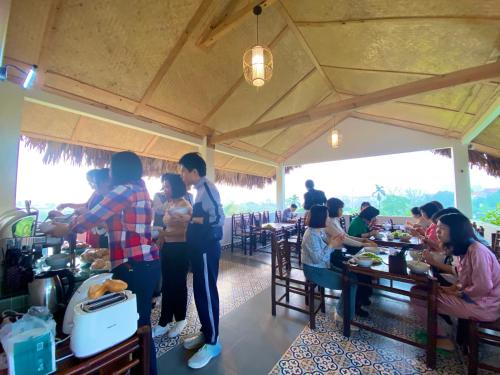 a group of people sitting at tables in a restaurant at Lemon Tree Homestay Tam Coc in Ninh Binh