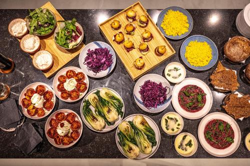a table with many plates of food on it at LUGANODANTE Boutique & Lifestyle Hotel in Lugano