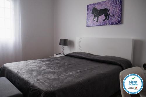 a bedroom with a bed and a painting of a black cat at Alves Nature Rooms in Arrifes