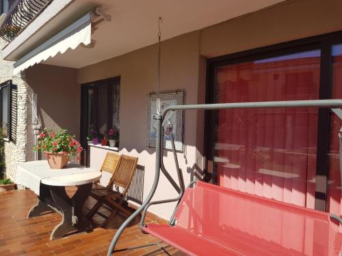 a porch with a red bench and a table at Apartments Helena Pomer in Pomer