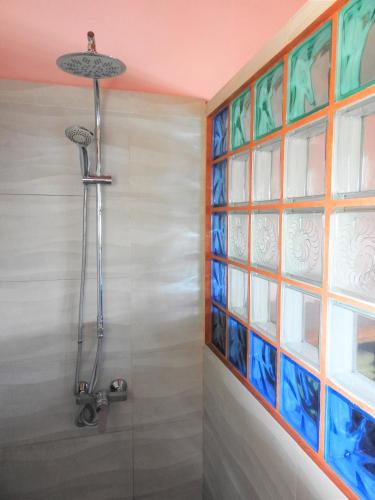 a shower in a bathroom with a glass wall at hotel trecicogne in Morondava