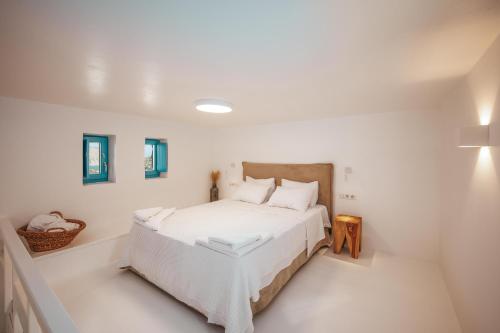 a white bedroom with a large white bed in it at Anemela Villas & Suites Mykonos in Agrari