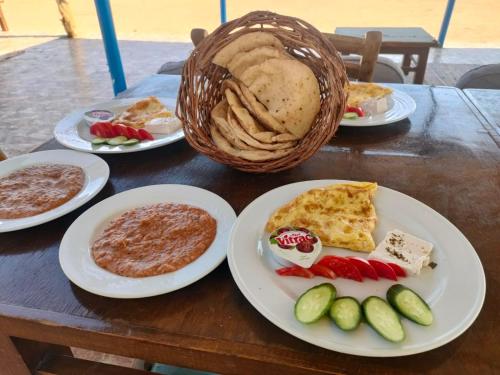 un tavolo con piatti di cibo e un cesto di pane di OASIS Resort a Nuweiba‘ el Muzeinah