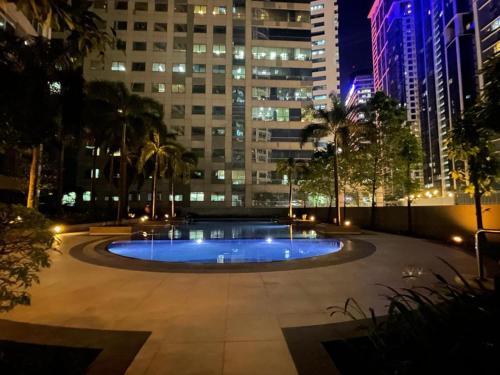 - une grande piscine au milieu d'une ville la nuit dans l'établissement EJ's Staycation 22nd F with 200mbps Wi-Fi and NETFLIX, à Manille