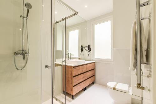 La salle de bains est pourvue d'un lavabo et d'une douche en verre. dans l'établissement AP Embajadores X, à Madrid