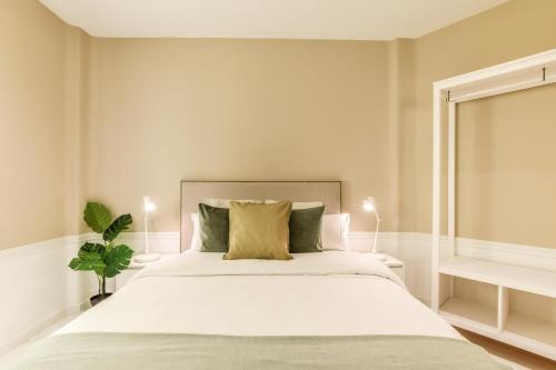 - une chambre avec un grand lit et des draps blancs dans l'établissement AP Embajadores X, à Madrid