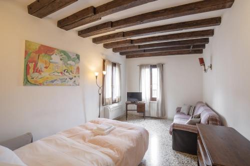 a bedroom with a bed and a couch and a table at Ca dei Arsenaloti, appartamento in Biennale in Venice