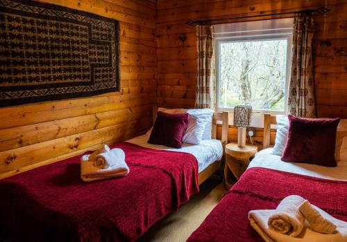 1 dormitorio con 2 camas en una cabaña de madera en Rona en Duirinish