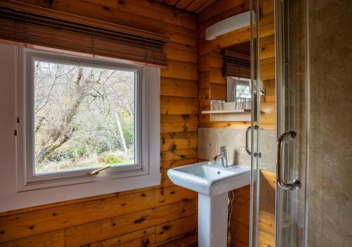 łazienka z umywalką i oknem w obiekcie Rona w mieście Duirinish