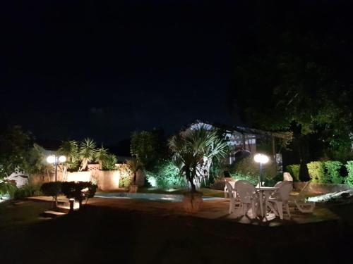 a patio at night with tables and lights at Casa De Campo Boituva in Boituva