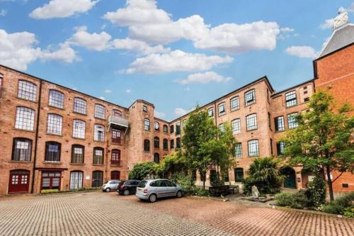 een rij bakstenen gebouwen met auto's geparkeerd op een parkeerplaats bij Charming 2 Bed Apartment in Centre of Nottingham in Nottingham