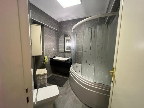 a bathroom with a tub and a toilet and a sink at Large Luxurious Apartment in Cairo
