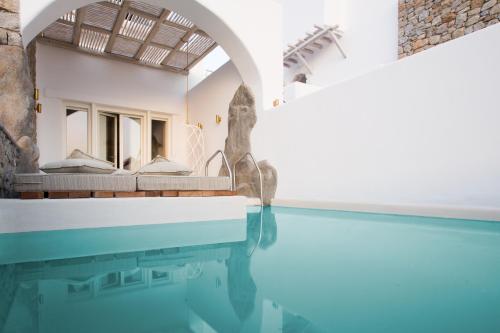 a villa with a swimming pool and a house at Kove Mykonos - A Myconian Collection Hotel in Ornos