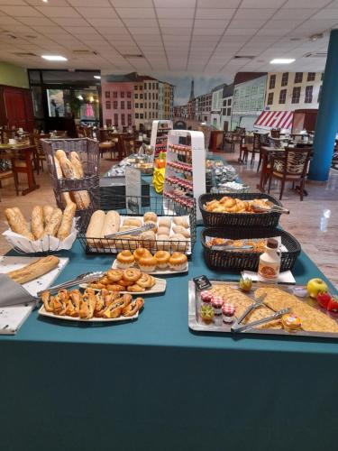 Hôtel Marso في أمنيفيل: طاولة مليئة بمختلف أنواع الخبز والمعجنات