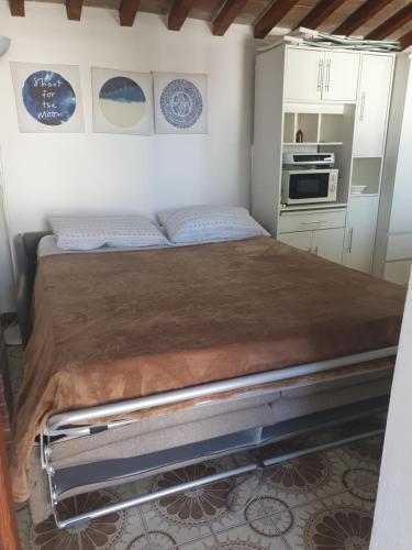 a bed in a small room with a kitchen at La Corte in Marciana Marina