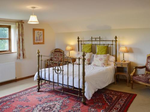 a bedroom with a bed and a red rug at Heckingham Manor in Loddon