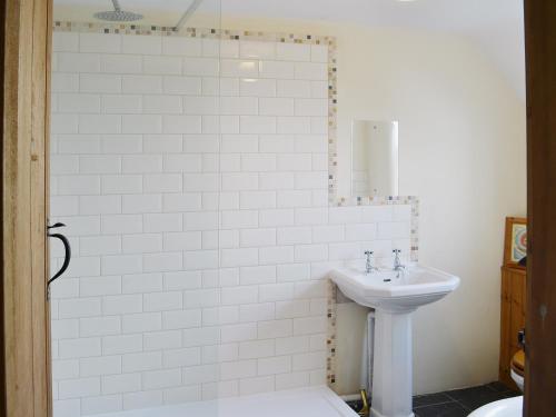 a white bathroom with a sink and a toilet at Heckingham Manor in Loddon