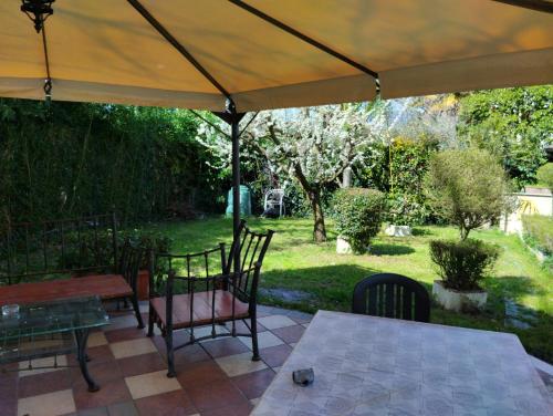 un patio con mesa y sillas bajo una sombrilla en B&B Angolo Verde, en Terni