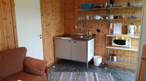 Överammers Cabins في Stugun: مطبخ بجدران خشبية وكاونتر في الغرفة