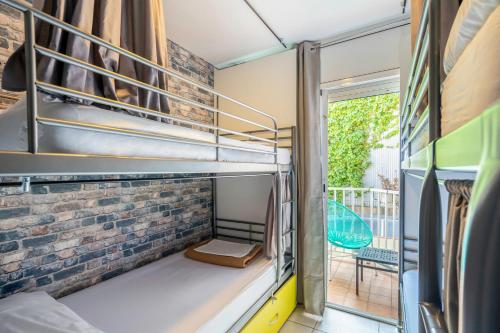 a room with two bunk beds and a balcony at Casa Barcelo Camp Nou Barcelona in Hospitalet de Llobregat