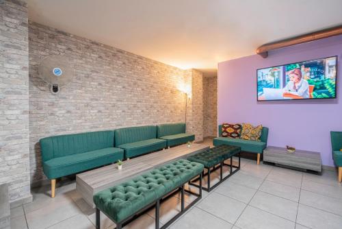 a waiting room with green couches and a tv at Casa Barcelo Camp Nou Barcelona in Hospitalet de Llobregat
