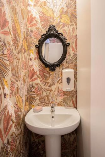 a bathroom with a sink and a mirror at Casa Barcelo Camp Nou Barcelona in Hospitalet de Llobregat