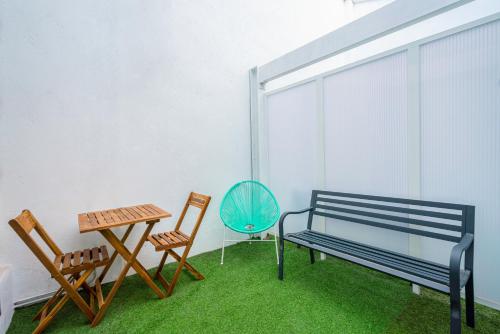 a room with a bench and two chairs and a table at Casa Barcelo Camp Nou Barcelona in Hospitalet de Llobregat