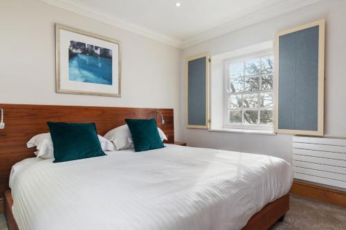 a bedroom with a large white bed and two windows at Slebech Park Estate in Wiston