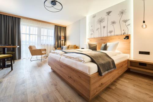 Schlafzimmer mit einem großen Bett mit einem Kopfteil aus Holz in der Unterkunft Appartementhaus Silvia in Bad Füssing