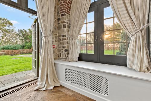 a window seat in a room with large windows at Slebech Park Estate in Wiston