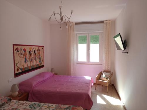 a bedroom with two beds and a window at Brezza Marina a 30 mt dalla spiaggia in Marina di Castagneto Carducci