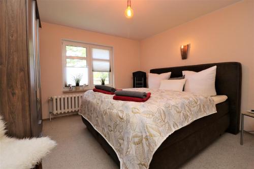 a bedroom with a large bed with red pillows on it at Ferienwohnung Krull in Wustrow