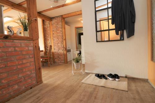 a hallway with a brick wall and shoes on a rug at Ferienwohnung Krull in Wustrow