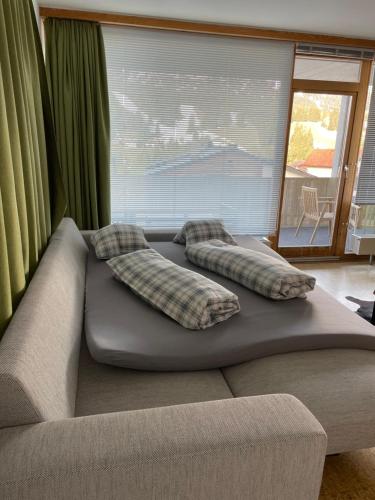 a bed in a living room with two pillows on it at 2 Zimmer Wohnung in Lenzerheide