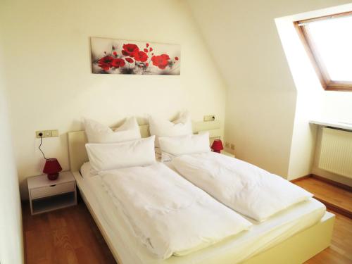 1 cama blanca con almohadas blancas en una habitación en Ferienwohnung Nadine en Calw