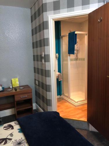 un bagno con doccia, un letto e una scrivania di Springfield Hotel a Blackpool