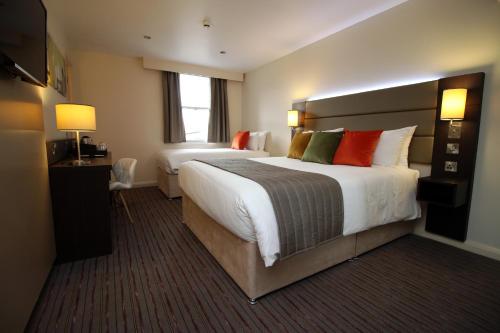 a large hotel room with two beds and a window at Silurian Hotel Newport in Newport