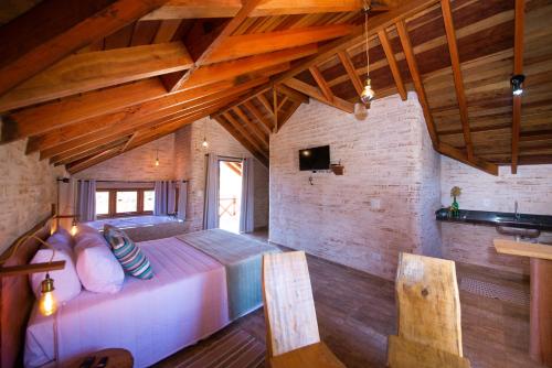 a bedroom with a large bed and wooden ceilings at Pousada Alpes da Mantiqueira in Monte Verde