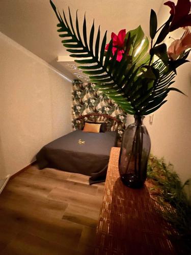 un vase avec des fleurs sur une table dans une chambre dans l'établissement Les tropiques de la baie, à Ponthoile