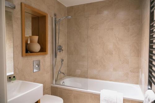 a bathroom with a shower and a toilet and a sink at Regent House deluxe 2 bedroom apartment in Harrogate